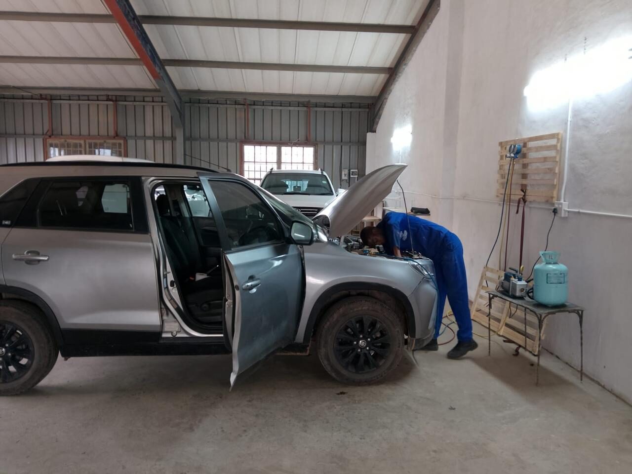 Airsteem technician servicing an SUV air-conditioning system